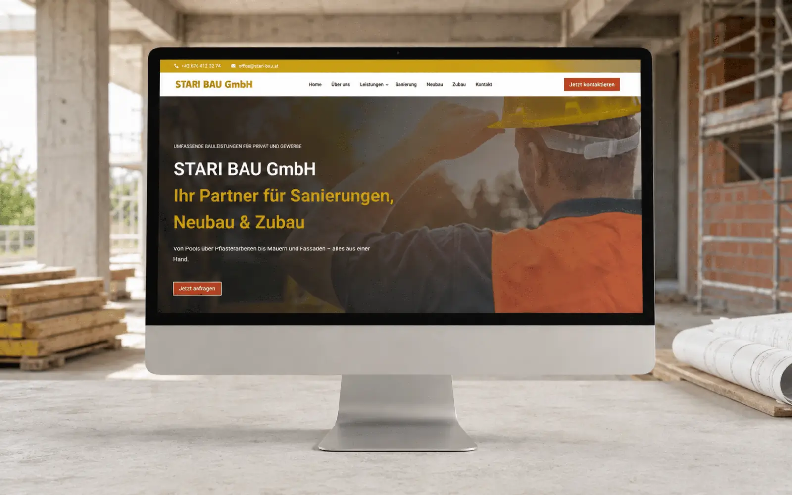 Startseite der Website der Stari Bau GmbH als Desktop-Mockup auf einer Baustelle